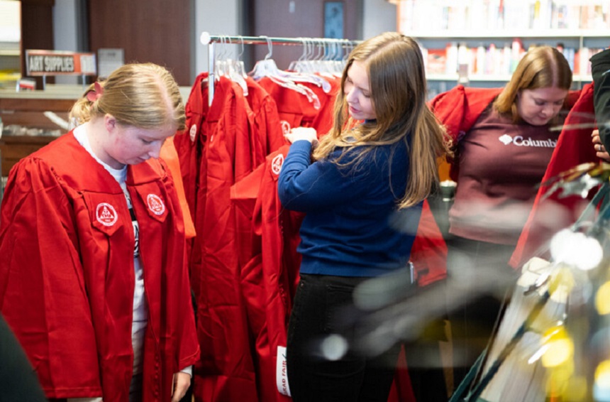 graduates trying on cap and gown